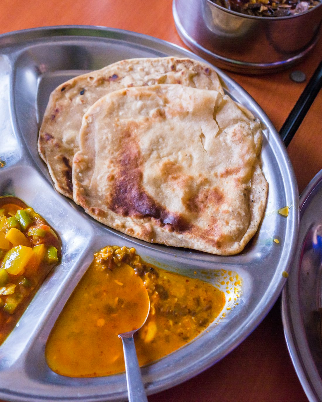Plated Bengali thali with curries and naan